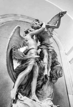 an angel statue with two people on it's back and one holding the arm of another