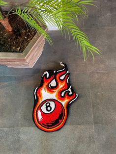 a pool ball rug on the floor next to a potted plant