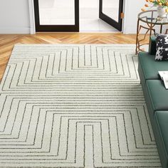 a living room with a green couch and white rug