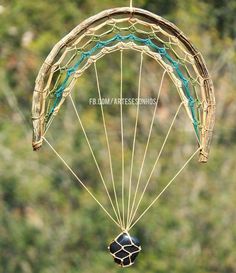 a parasail being flown in the air with trees in the background