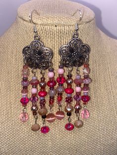 These earrings will put you in the very trendy color of pink. Strands of beautiful pink, purple and peach beads drip down from intricate silver tone flowers. Beads include vintage, modern and glass beads. These are on the longer side but they are not at all heavy. Pink Beaded Drop Flower Earrings, Pink Dangle Flower Earrings With Colorful Beads, Pink Bohemian Chandelier Earrings For Party, Bohemian Pink Chandelier Earrings For Party, Pink Flower Earrings With Dangling Round Beads, Nickel-free Pink Beaded Earrings, Elegant Pink Flower Earrings With Dangling Beads, Elegant Pink Chandelier Earrings With Dangling Beads, Pink Large Bead Dangle Earrings