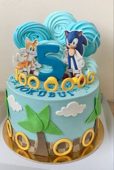 a blue and yellow birthday cake with sonic the hedgehog on top