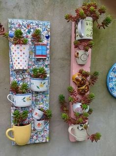 two planters are attached to a wall with succulents and mugs