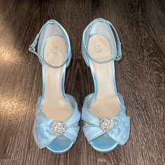 a pair of blue high heeled shoes sitting on top of a wooden floor