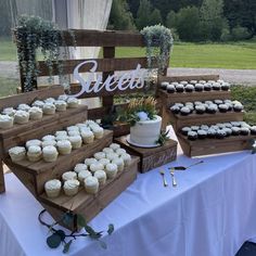 a table topped with lots of cupcakes next to a sign that says sweet