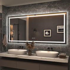 a bathroom with two sinks and a large mirror on the wall above it's counter