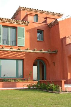 an orange house with green shutters and windows