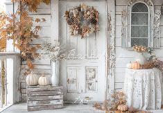 an old white house decorated for fall with pumpkins and gourds