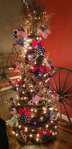 a christmas tree decorated with red, white and blue decorations in a basket on top of a wooden table