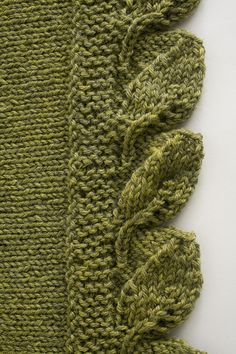 a green knitted scarf with ruffled edges