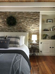 a bedroom with stone walls and wood floors