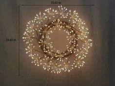 a lighted wreath on the wall is shown with measurements to make it look like fireworks