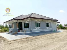 a small gray house sitting on top of a dirt road