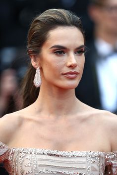 an image of a woman with long hair in a gown and earrings on the red carpet