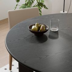 a bowl of fruit sitting on top of a wooden table