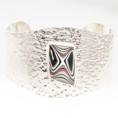 Fordite Luxury Cuff has 55 grams of sterling silver!  This is your statement piece.  Comfortable on wrists that wear about a 7″ to 8 1/2″ bracelet or bangle. Sterling Silver and Nickel Free.  Gift Box included. Every piece of Fordite, also known as Detroit Agate, is a unique object of beauty. Like agate Fordite is cut and polished to reveal the swirling patterns of colors inside. Unlike agate, Fordite comes not from the ground but from the retired paint shops of the automotive industry. In the o Hammered Bracelet, Chunky Bracelets, Hammered Sterling Silver, Statement Bracelet, Hammered Silver, Silver Cuff, Statement Jewelry, Bracelet Making, Cuff Bracelets