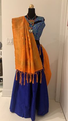 Blue chanya choli with orange dupatta. Blue chanya(skirt) has made up of Tafeta silk. Brocade Blouse with unique pattern of blue and golden threads comes with extra sleeves. Orange dupatta with golden zari threads. Item Contain : Blue and orange chanya choli set Chanya(skirt) Length : 42 Inches Blouse Length : 14.5 Inches Sleeves : Sleeveless (But it has extra sleeves of length 5 Inches) Item In Box: 3 pc outfit Color : Blue ( As Shown In Image ) Fit Type : Regular Fit Occasion: Will add luster when worn for a wedding, engagement, party, prom, navratri(garba) and any special occasion. It will enhance special days like Valentine's Day, Birthdays, Anniversaries and Mother's Day Gift. Color Declaration: There Might Be Slight Variation In The Actual Color Of The Product Due To Different Screen Blue Bollywood Banarasi Silk Pre-draped Saree, Blue Paithani Silk Pre-draped Saree With Traditional Drape, Traditional Blue Pre-draped Saree For Navratri, Semi-stitched Choli For Traditional Ceremonies During Diwali, Traditional Blue Pre-draped Saree For Festivals, Traditional Blue Pre-draped Saree With Dupatta, Transitional Blue Pre-draped Saree With Unstitched Blouse, Festive Transitional Dola Silk Choli, Banarasi Silk Dupatta With Latkans For Traditional Ceremonies