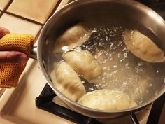 some dumplings are being cooked in a pot on the stove