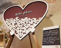 a heart shaped sign with hearts on it next to a chalkboard and easel