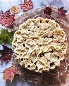 a pie sitting on top of a table covered in leaves