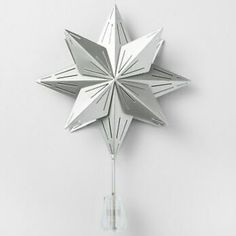 a silver star shaped clock on a white wall