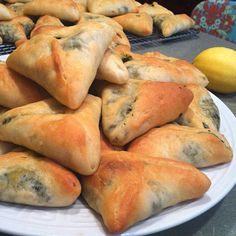 a white plate topped with pastries on top of a table next to lemons