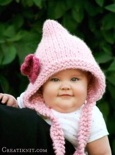 a baby wearing a pink knitted hat