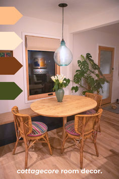 a dining room table with four chairs and a potted plant in the corner on the far wall