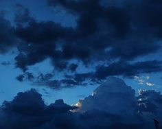 the sky is dark and cloudy at night with some clouds in it's foreground