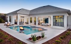 a house with a pool in the middle and fire pit on the front patio area