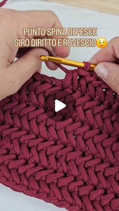 someone is crocheting the bottom part of a red bag with a yellow knitting needle