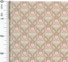 a ruler is next to a wallpaper with pink and beige flowers on brown background