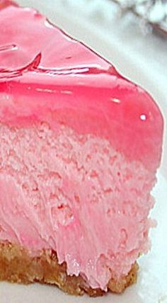 a piece of cake with pink frosting on it sitting on a white plate next to a fork