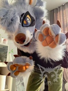 a stuffed animal is standing in front of a window with its hands up to the camera