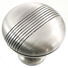 a close up of a metal knob on a white surface with lines painted on it