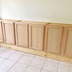 an unfinished kitchen cabinet with white tile flooring