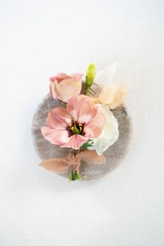 three flowers sitting on top of a white surface