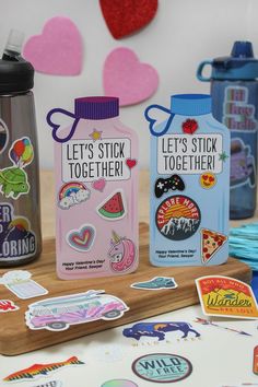 several stickers and magnets are displayed on a wooden table with hearts in the background