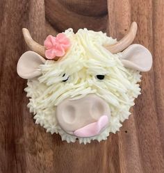 a cupcake shaped like a cow with horns and flowers on it's head