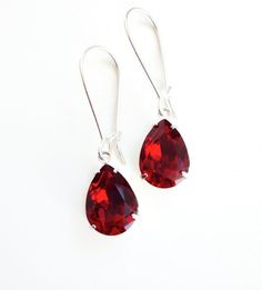 "Red Crystal Pear Drop Earrings These stunning earrings look like real luxe gemstones with all the bling at an affordable price. I handset the medium (14x11mm .5\"x.4\") siam red shade Swarovski Crystal in silver-plated open back teardrops and hung them from matching kidney style ear wires for a total length of 1.25\". The perfect accessory for the holidays or special events including weddings.  Return to shop: http://LoveYourBling.etsy.com Copyright ©, all rights reserved. www.LoveYourBling.com Tornado Season, Crystal Dangle Earrings, Red Crystals, Stunning Earrings, Bridesmaid Earrings, Bridesmaid Jewelry, Shades Of Red, Tornado, Stone Earrings