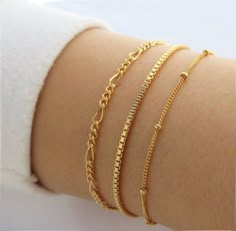 Handmade in high-quality 14k Gold Filled, these smooth and dainty bracelets are the perfect addition to your collection. These bracelets layer well with other dainty pieces and are comfortable for everyday wear! The perfect gold bracelets at an affordable price point. This listing is for one bracelet. From the left side: Figaro, Box Cain, and Bead Chain. The bracelet lengths are in inches. Please measure your wrist with a piece of string or measuring tape at the fit that is most comfortable. If Cheap Minimalist Bracelet With Delicate Chain, Cheap Gold Bracelets With Adjustable Chain, Cheap Minimalist Bracelets With Delicate Chain, Affordable Minimalist Bangle Chain Bracelet, Cheap Adjustable Minimalist Bracelets, Cheap Gold Adjustable Chain Bracelet, Cheap Dainty Gold Bracelet, Cheap Dainty Yellow Gold Bracelet, Cheap Casual Bracelet Strap Jewelry