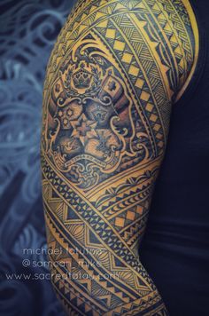 a man's arm with an intricate tattoo design on his arm and shoulder,