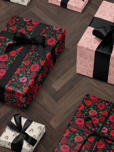 several wrapped presents are on the floor with black ribbons and bows, all decorated in pink roses