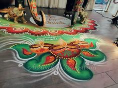 a colorful rangolite design on the floor in front of a stage with candles