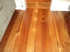 an empty kitchen with wood floors and white cabinets