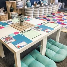 a table with several different colored cushions on it and some baskets in the back ground