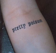 a person with a tattoo on their arm that says pretty prison in cursive writing