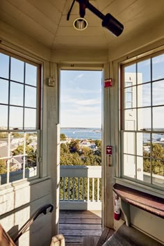 an open door leading to a porch with a view of the ocean in the distance