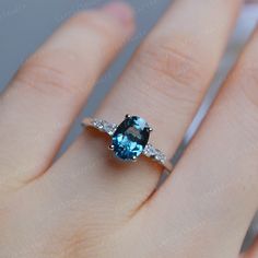 a woman's hand with a blue and white diamond ring