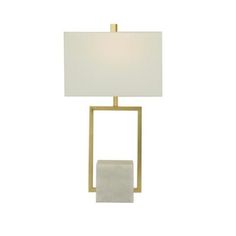 a table lamp with a white shade on the top and a gold frame around it